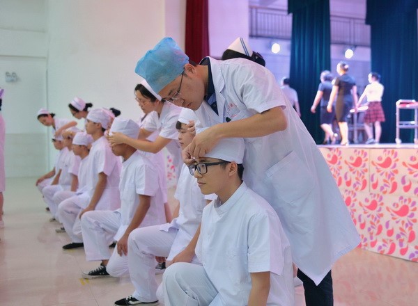 老师们为同学们带上圣洁的燕尾帽